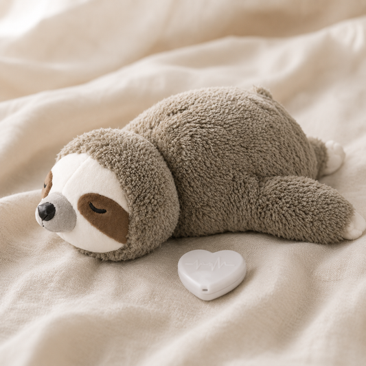 Comfort Companion sloth plush with its removable heart-shaped heartbeat module shown beside it